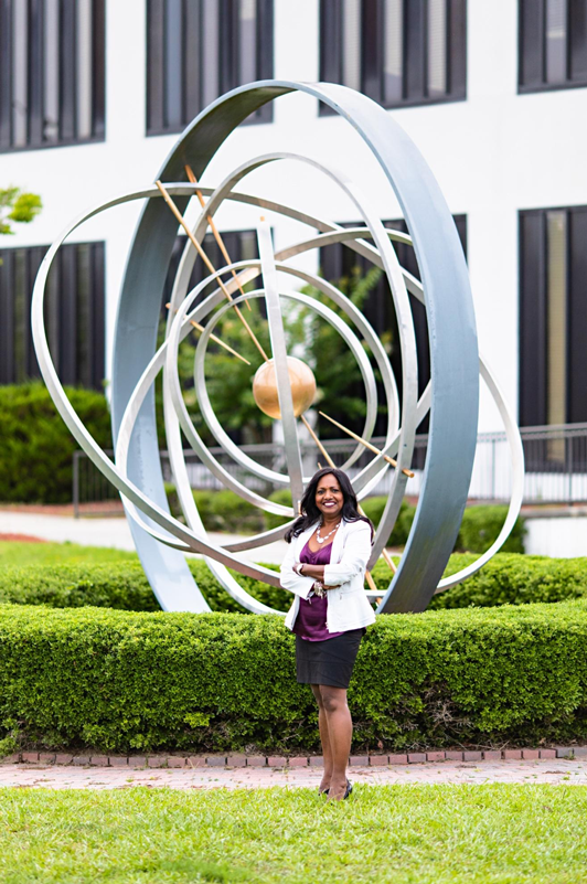 Jhansi Kandasamy in front of the atom at the GE Hitachi Nuclear headquarters in Wilmington, N.C. Photo courtesy WILMA Magazine.